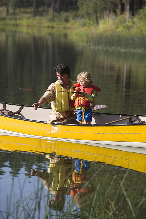 Father and child fishing in a canoe Photograph by Comstock Images