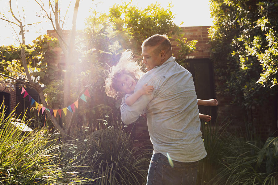 Father and little daughters happy jumping moments in garden Photograph by Attila Csaszar