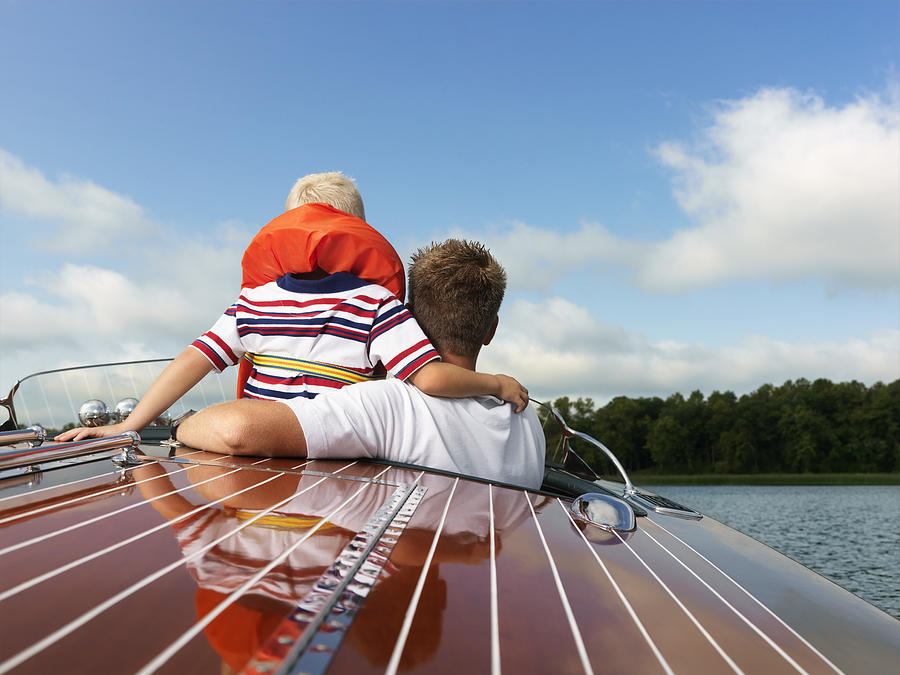 Father and Son in an Old Speed Boat Photograph by Fuse