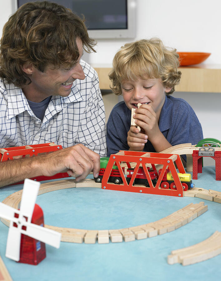 Father and Son Playing With a Toy Train Photograph by Digital Vision.