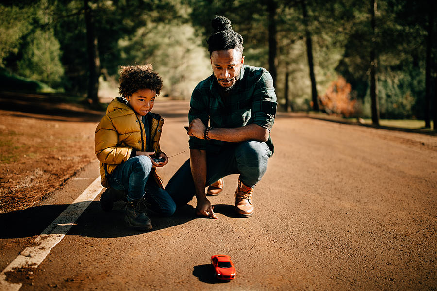 Father and son playing with remote controlled car in nature Photograph by Wundervisuals