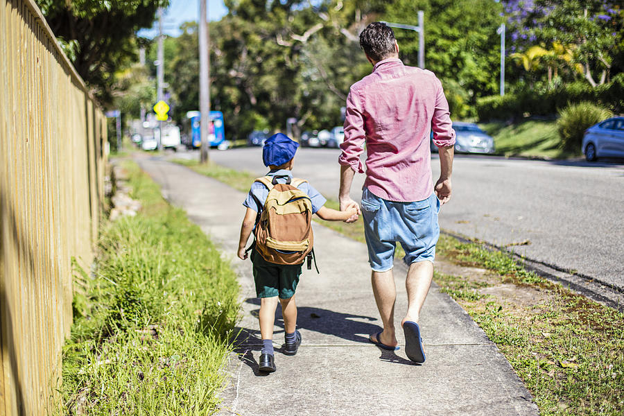 Father and son walking to school Photograph by Xavierarnau