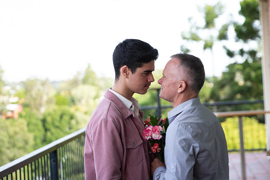 Father and son with a flower looking at each other closely Photograph by Attila Csaszar