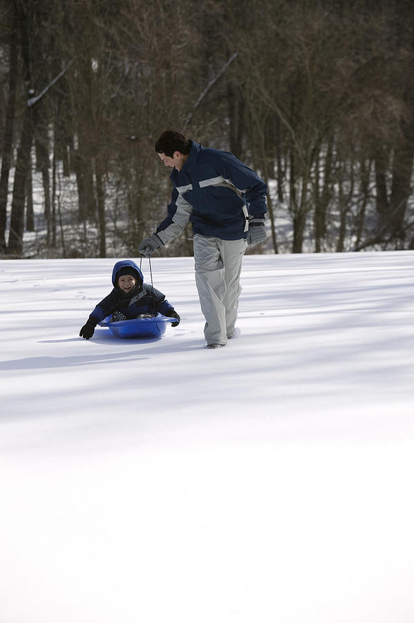 Father and son with a sled Photograph by Comstock Images