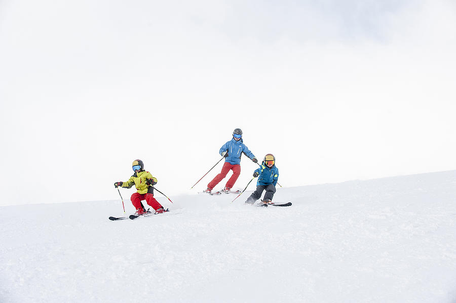 Father and two sons skiing together Photograph by Westend61