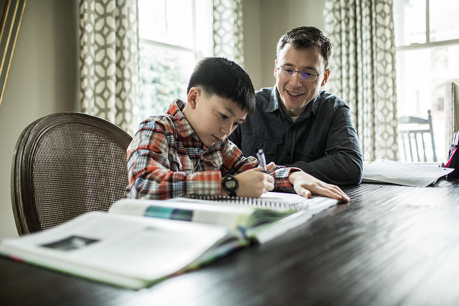 Father helping son with homework Photograph by MoMo Productions