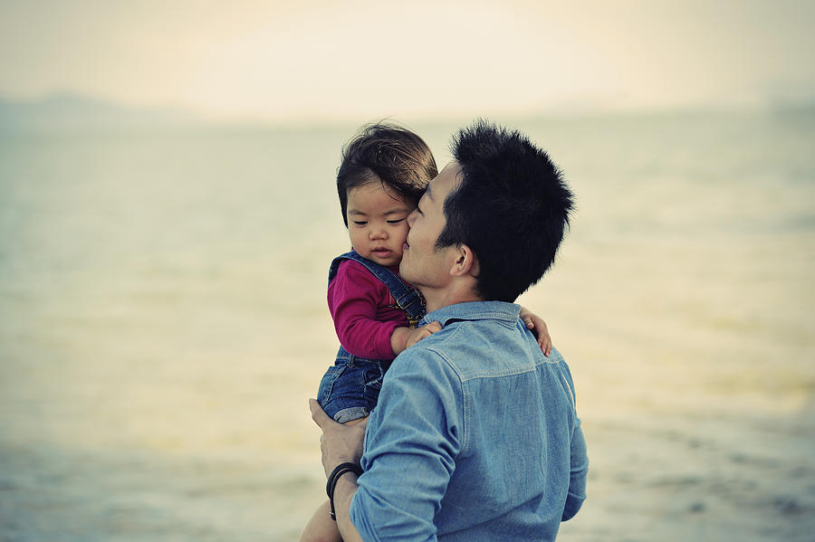 Father Kissing?daughter on beach Photograph by Yagi Studio