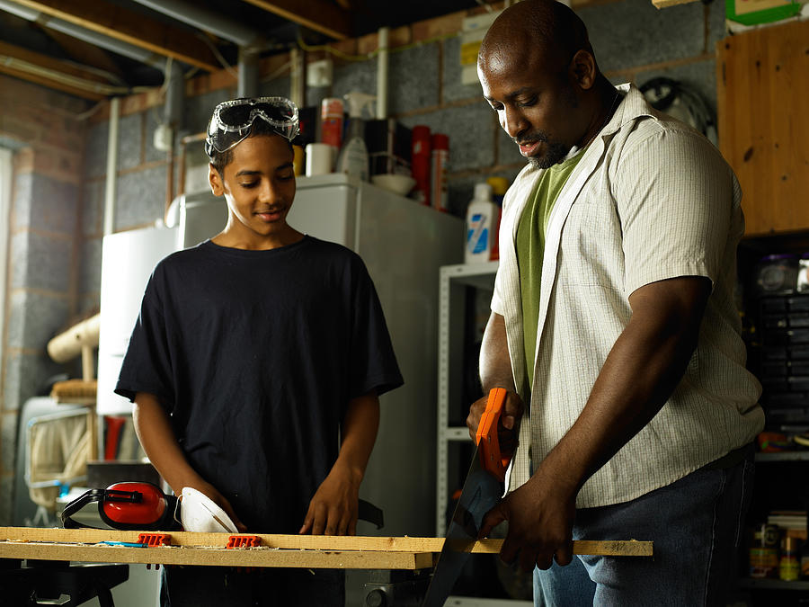 Father teaching Son carpentry skills Photograph by John Howard
