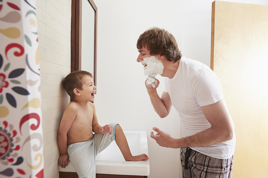Father teaching son to shave in bathroom Photograph by Jasper Cole