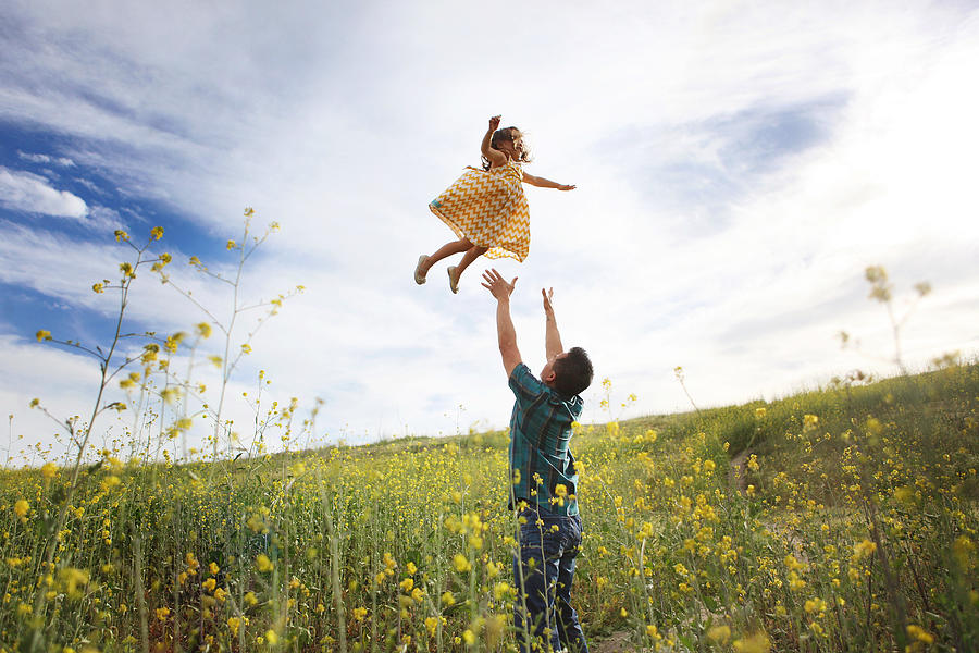 Father throwing daughter in the air Photograph by Noelbesuzzi