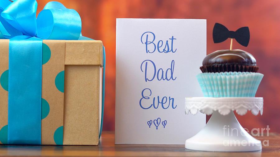 Fathers Day close up of woman arranging and setting up gift, cupcake and card Photograph by Milleflore Images
