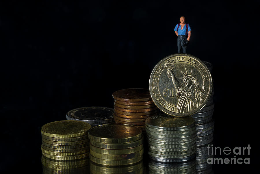 FED interest rate reduction percentage, Federal Reserve concept, miniature people businessman ton top of coin stacks with US dollar black background. Macro Photograph by Pablo Avanzini