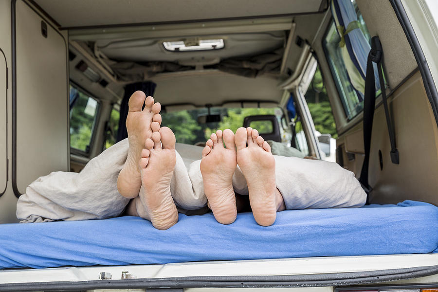 Feet of a couple lying on mattress in van Photograph by Westend61