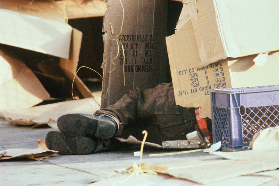 Feet of homeless person sleeping in cardboard box Photograph by Joe McBride
