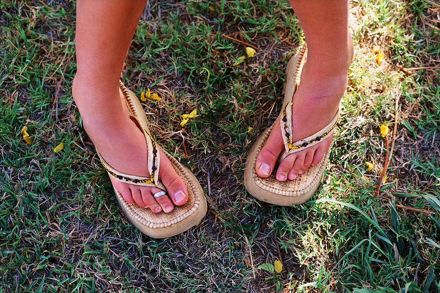 Feet of woman wearing sandals standing pigeon-toed Photograph by Thinkstock