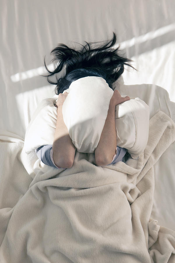 Female covering her face from a.m. sun with pillow Photograph by Tooga