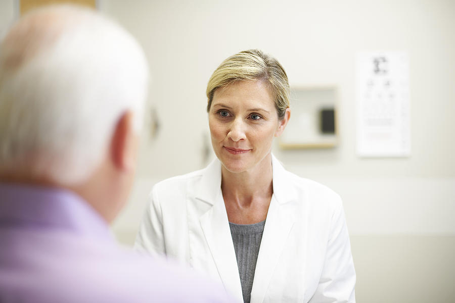 Female Doctor in conversation with mature patient Photograph by Thomas Northcut