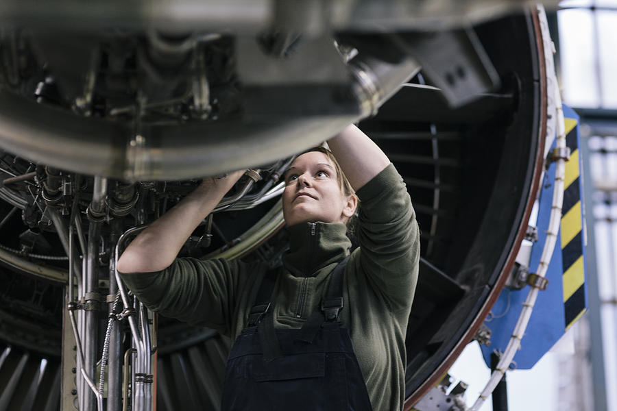 Female engineer working on jet engine Photograph by Hinterhaus Productions