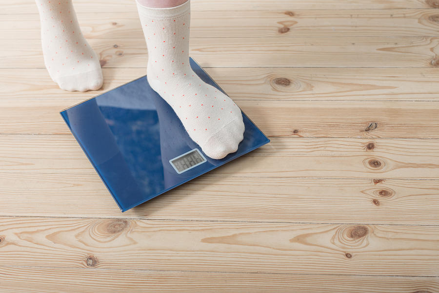 Female Feet In Socks On The Floor Scales Photograph by Maya23K