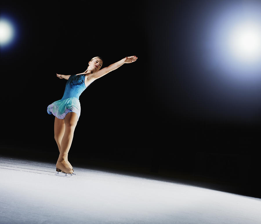 Female figure skater, performing on ice. Photograph by Robert Decelis