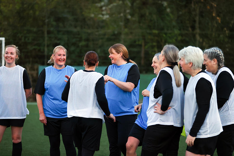 Female footballers smile during training Photograph by Catherine Ivill