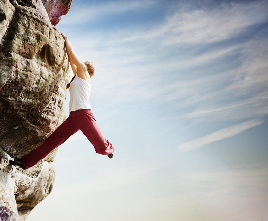 Female free climber hanging from boulder Photograph by Robert Decelis Ltd