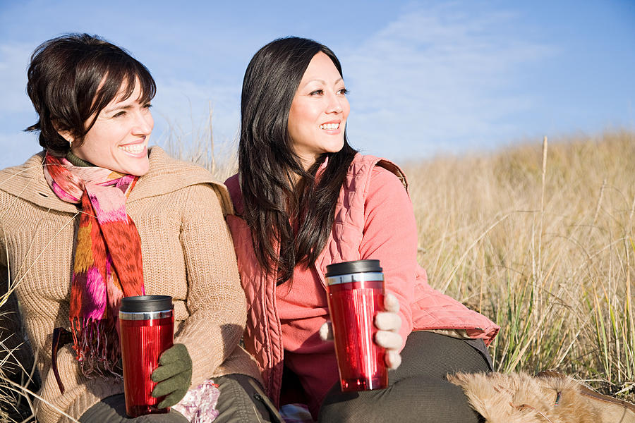 Female friends with drink flasks Photograph by Image Source