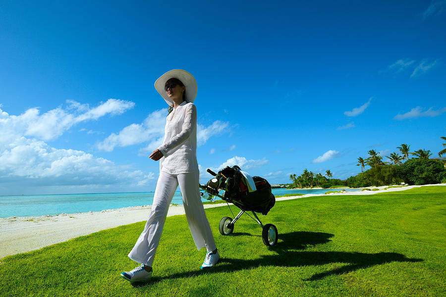 Female Golfer With Cart Walking On Beach Golf Course Photograph by PhotoTalk
