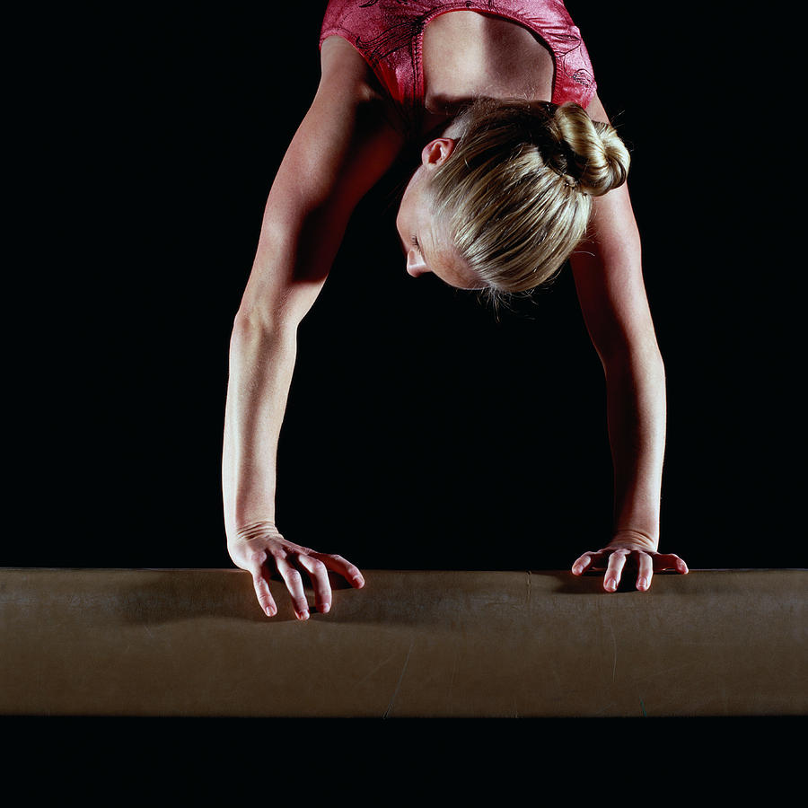 Female gymnast balanced on vault Photograph by Chad Baker/Jason Reed/Ryan McVay