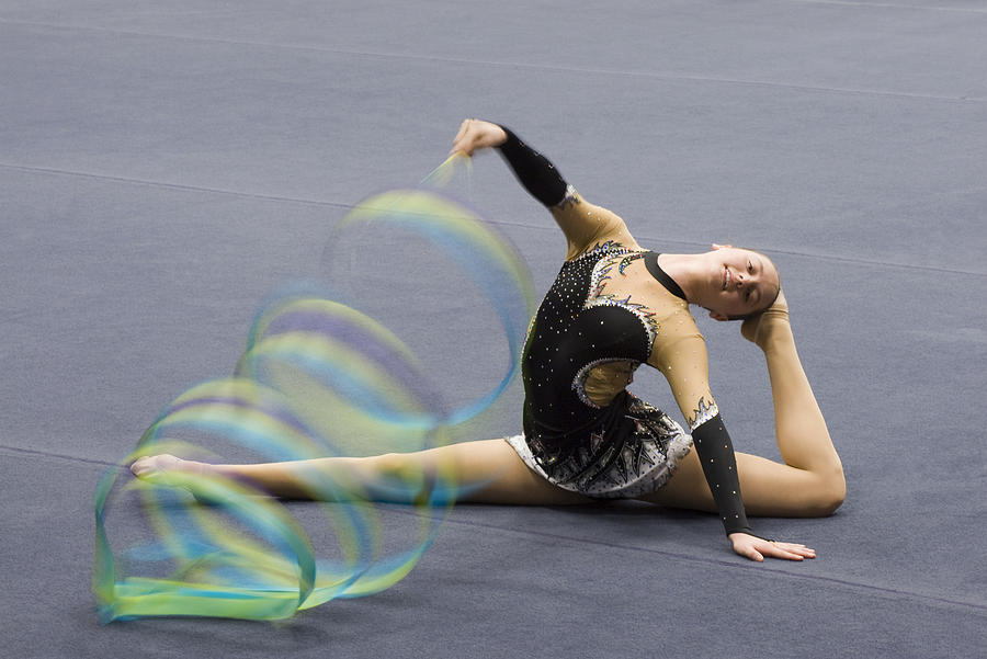 Female gymnast performing floor routine with ribbon Photograph by PhotoAlto/Odilon Dimier
