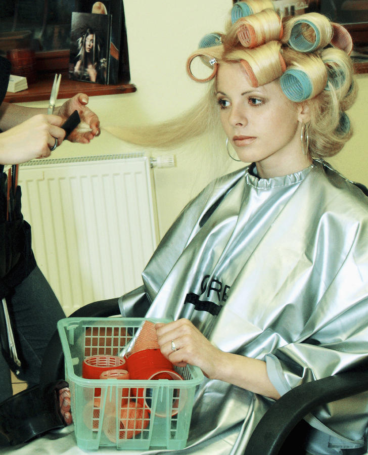 Female hairdresser cutting hair of a mid adult woman Photograph by Medioimages/Photodisc