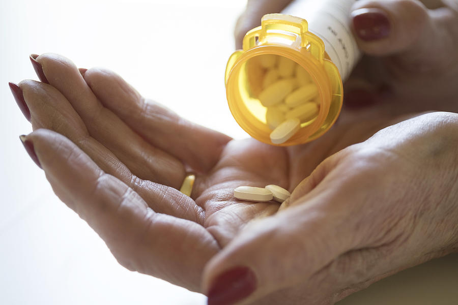 Female hand holding pill bottle Photograph by Tetra Images