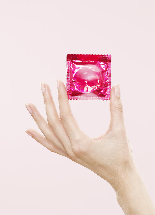 Female Hand Holding Sealed Condom Packet Photograph by Oppenheim Bernhard