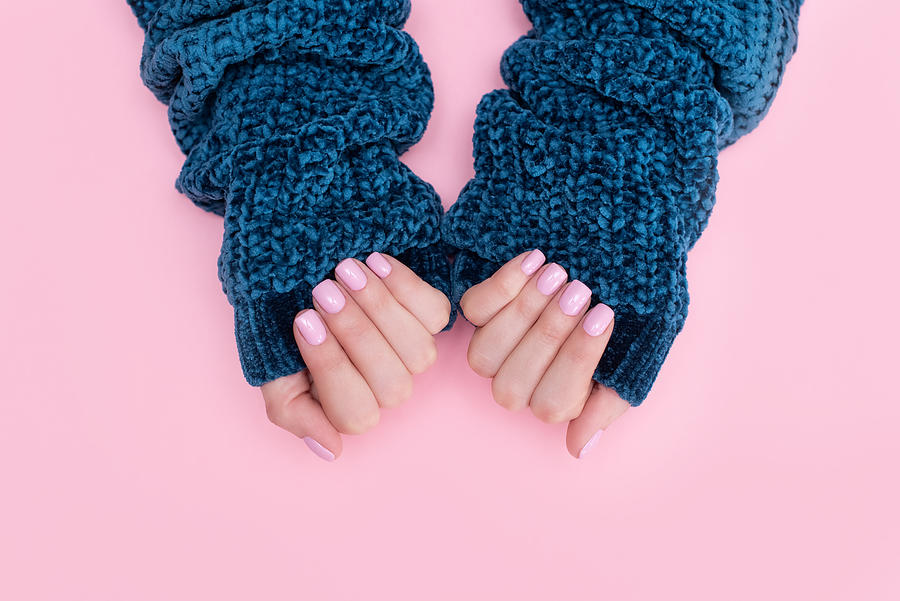 Female hands manicure close up view on pink knitted sweater background. Nail painting effects. Manicure salon banner concept Photograph by Kseniya Ovchinnikova