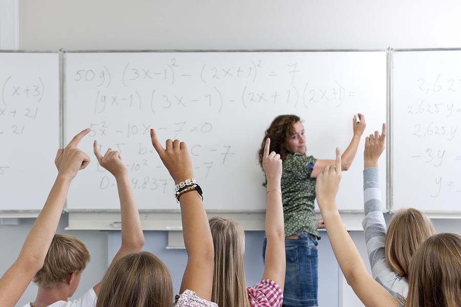 Female High School Teacher Writing Formula On Whiteboard In Classroom Photograph by Pidjoe