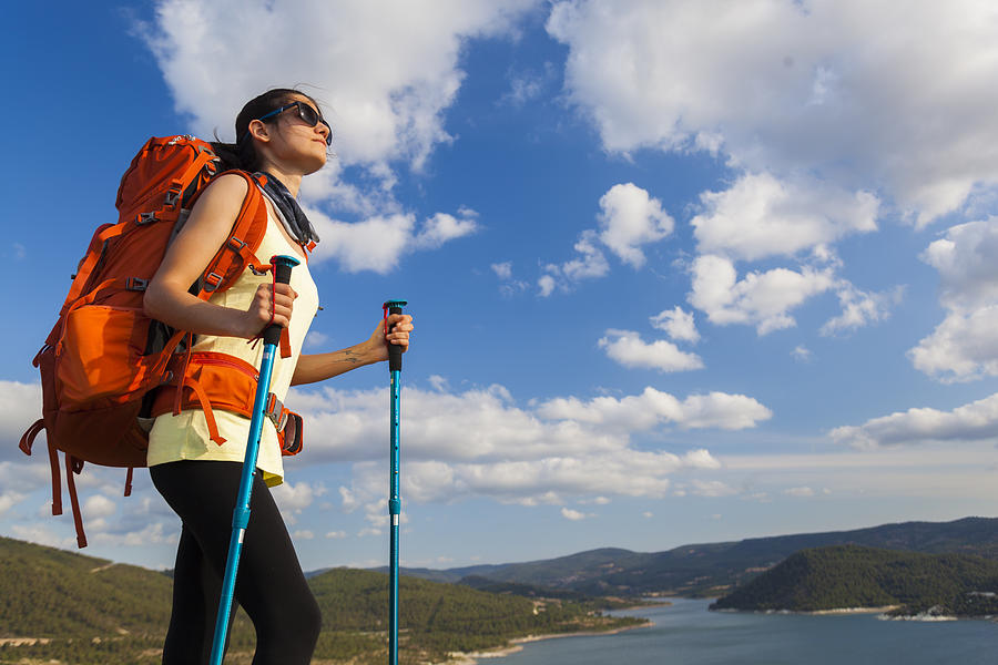 Female hiker climbing to mountain peak Photograph by Guvendemir