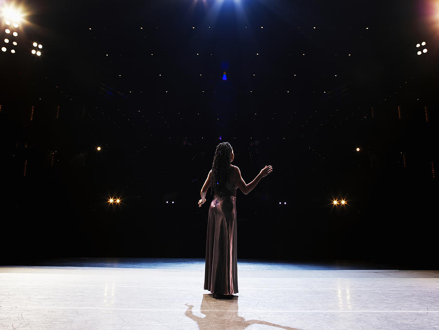 Female opera singer performing solo on stage, rear view Photograph by Thomas Barwick