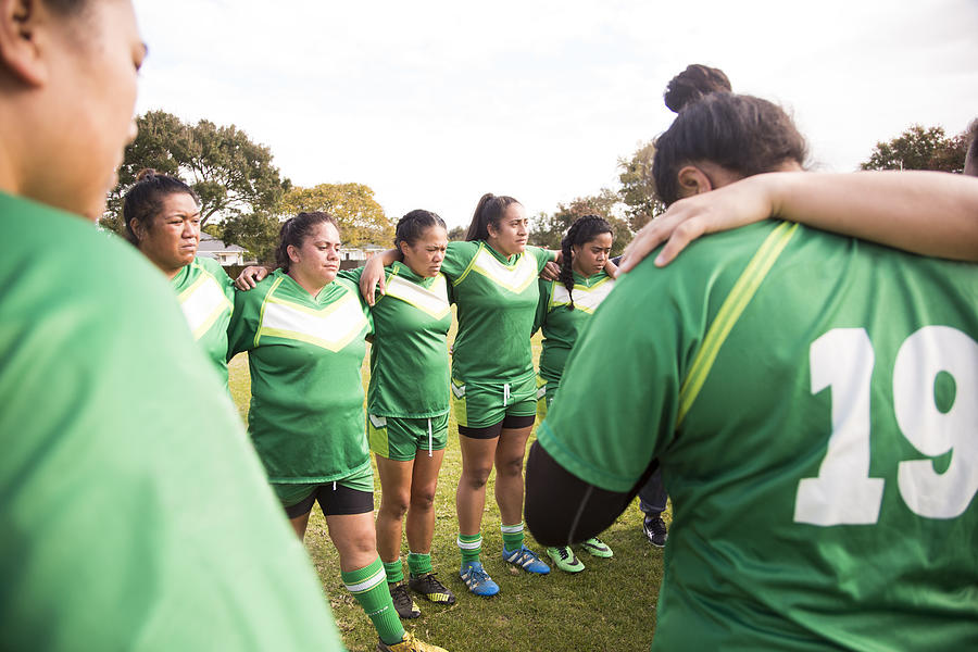 Female rugby players have team talk at side of pitch Photograph by Jessie Casson