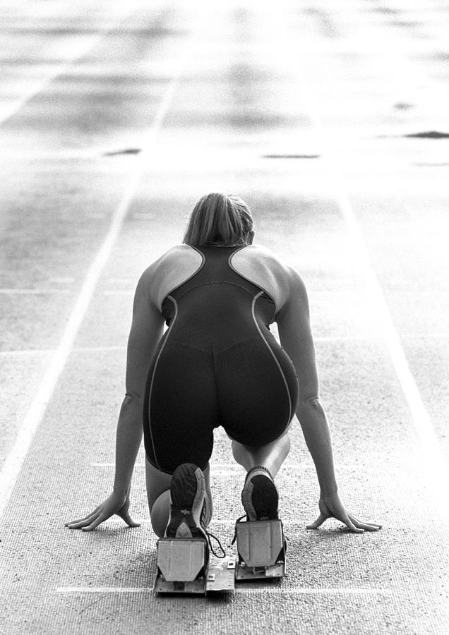 Female runner at starting line, rear view Photograph by Teo Lannie