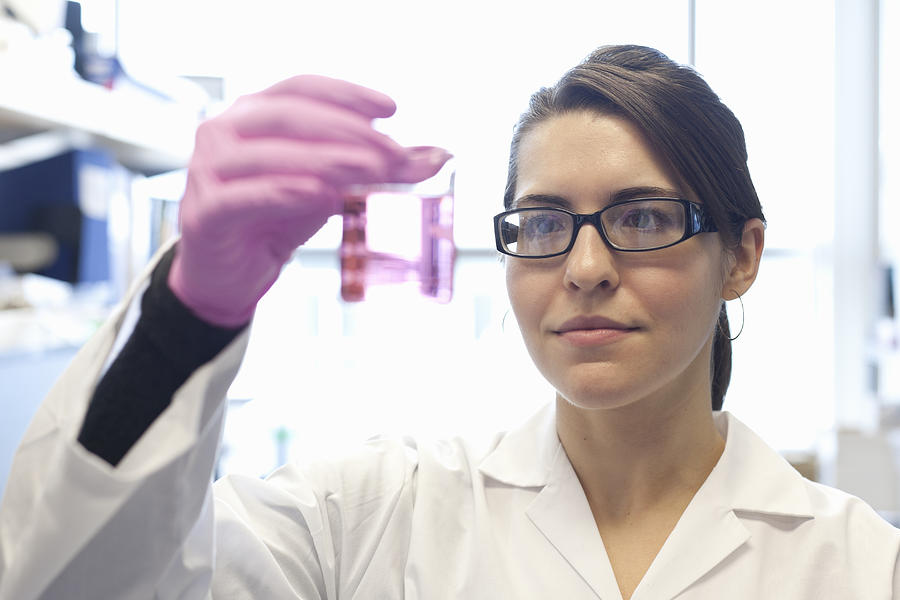 Female scientist  examines sample in lab Photograph by Assembly