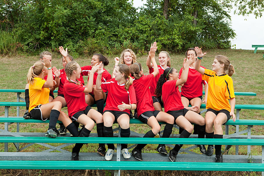 Female soccer team high fiving Photograph by Image Source