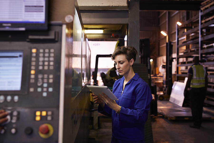 Female steel worker holding tablet inside factory Photograph by Klaus Vedfelt