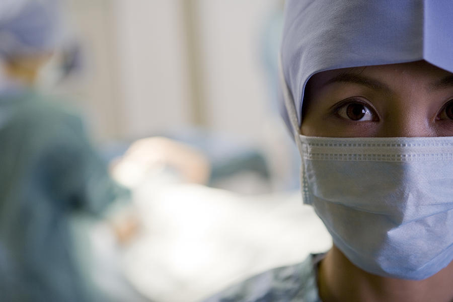 Female surgeon wearing face mask, close-up, portrait Photograph by Michael H