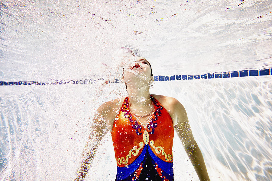 Female synchronized swimmer swimming to surface Photograph by Thomas Barwick