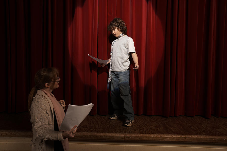 Female teacher and boy (10-12) standing on stage rehearsing Photograph by Adam Taylor