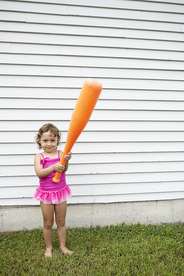 Female toddler in garden holding a large orange baseball bat Photograph by Robyn Breen Shinn