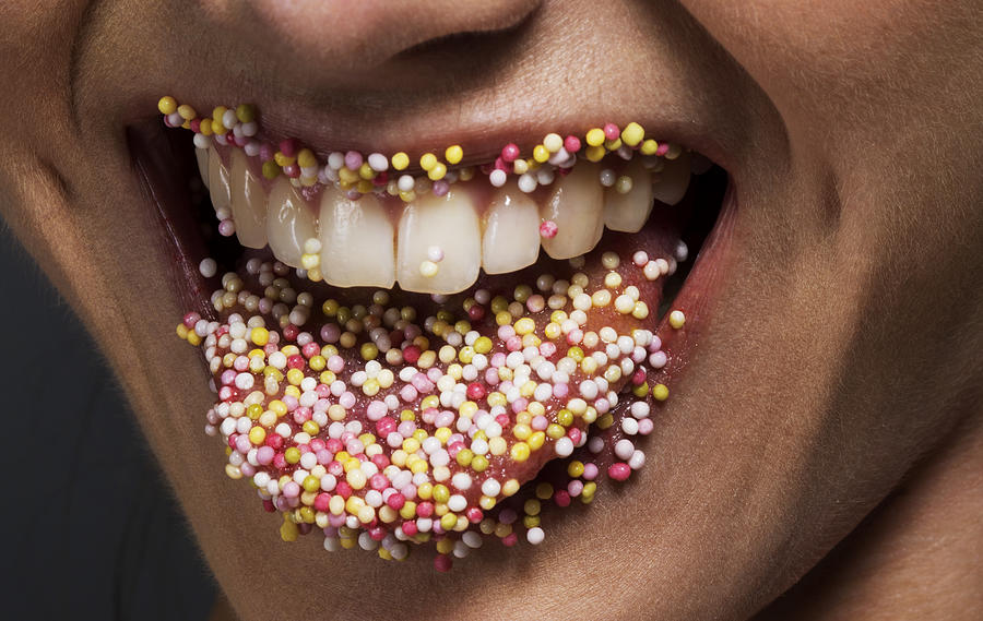 Female tongue and lips covered in sugar sprinkles Photograph by Jonathan Knowles