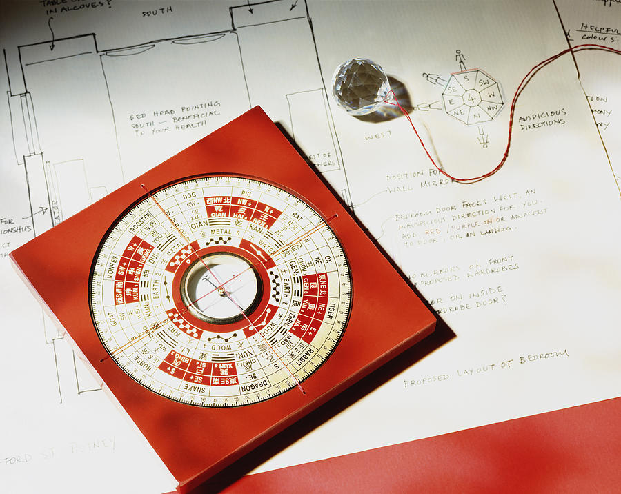 Feng shui compass and crystal on house plan, close-up, elevated view Photograph by Peter Dazeley