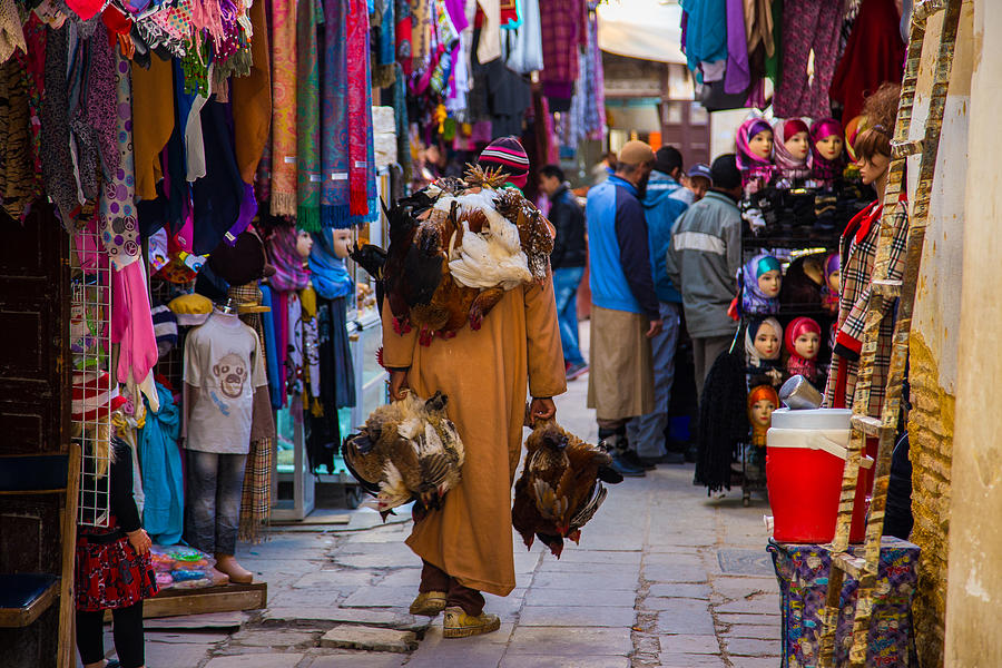 Fez medina colorful street and man carrying chiken Photograph by Artur Debat