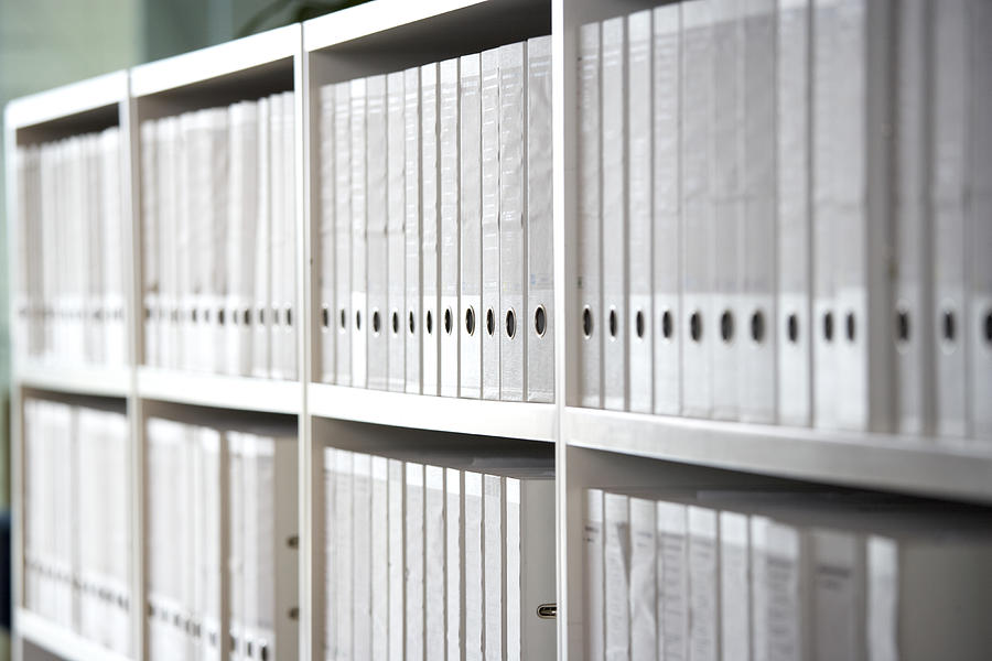 Files on shelves in an office Photograph by Alistair Berg